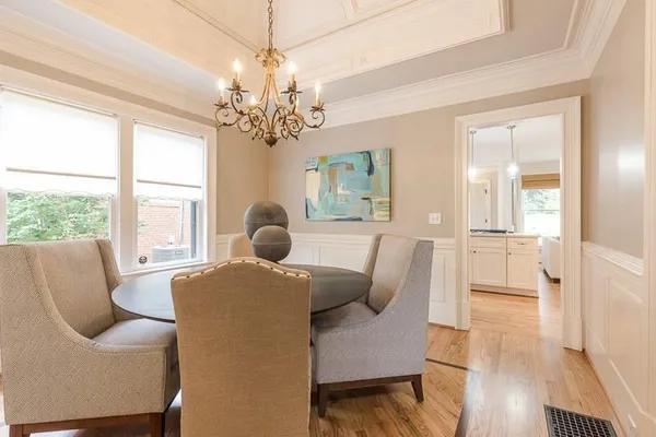 a living room with furniture a chandelier and wooden floor