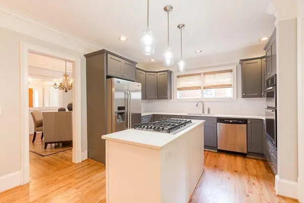 a kitchen with kitchen island a counter top space a sink stainless steel appliances and cabinets