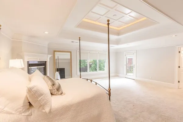 a large white bed in a hotel room next to a window