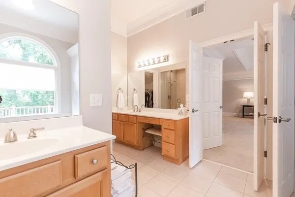 a spacious bathroom with a double vanity sink a mirror and a bathtub