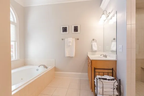 a bathroom with a tub sink and mirror