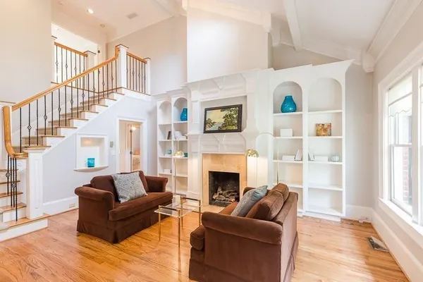 a living room with furniture fireplace and a window