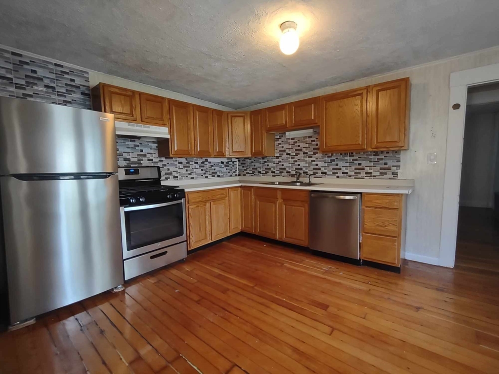a kitchen with stainless steel appliances granite countertop a refrigerator and a stove