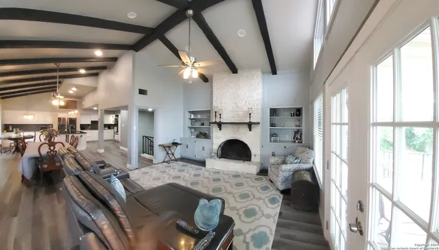 a open kitchen with stainless steel appliances granite countertop a stove a refrigerator a oven with white cabinets and wooden floor