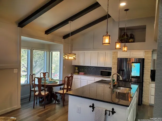 a kitchen with a table chairs and a ceiling fan