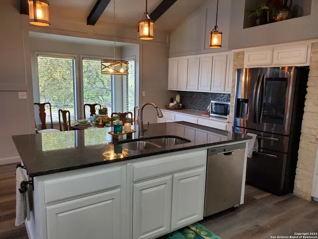 a kitchen with stainless steel appliances granite countertop a sink refrigerator and window