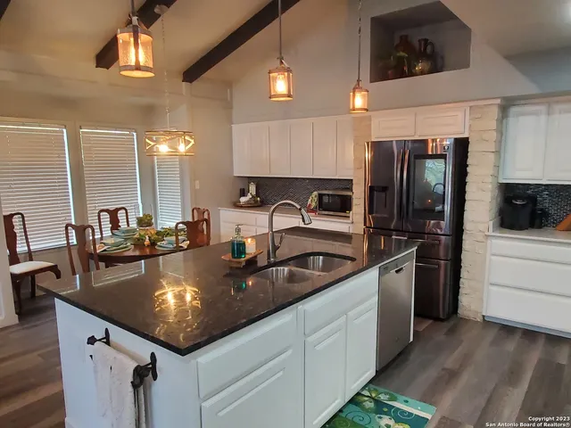 a kitchen with stainless steel appliances granite countertop a sink a stove and refrigerator
