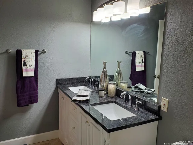 a bathroom with a granite countertop sink toilet and mirror