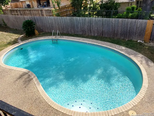 a view of a backyard with wooden fence