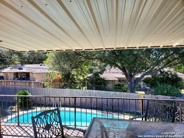 a balcony with wooden floor yard and outdoor seating