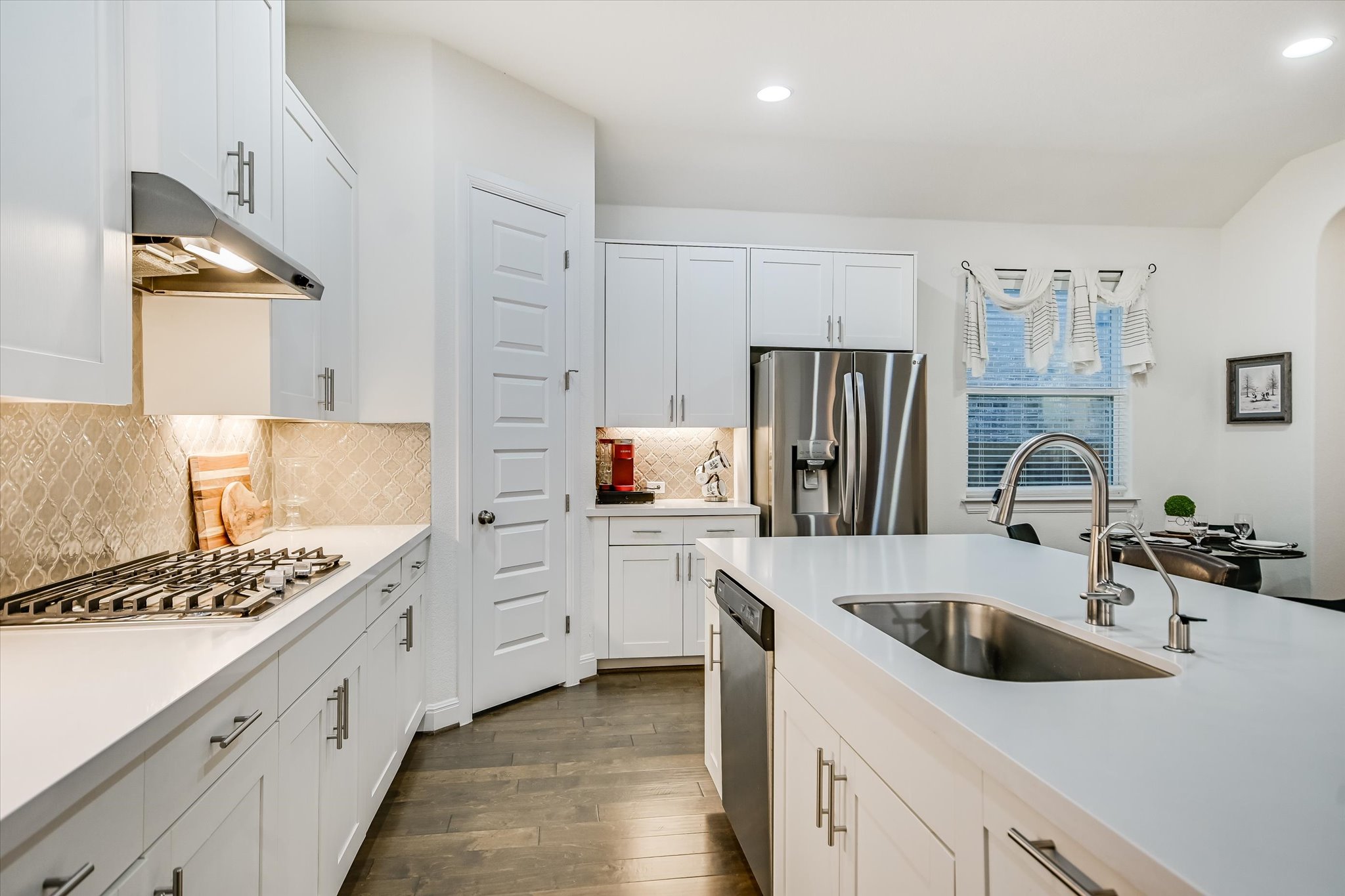 508 Peakside Circle Dripping Springs, TX 78620 - Photo 13 of 30 Kitchen with stainless steel appliances, dark wood-style floors, white cabinetry, recessed lighting, and light stone countertops