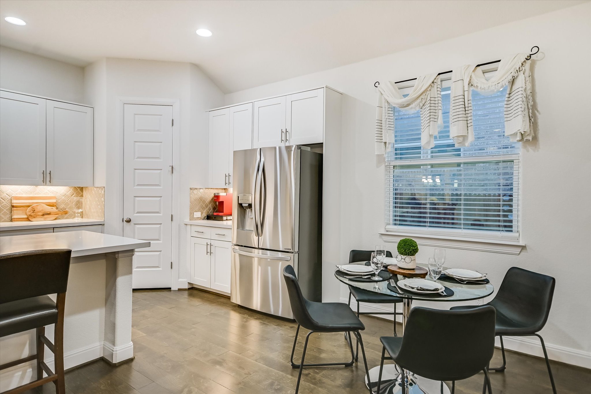 508 Peakside Circle Dripping Springs, TX 78620 - Photo 15 of 30 Kitchen featuring stainless steel refrigerator with ice dispenser, white cabinetry, dark wood finished floors, and recessed lighting