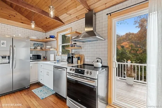 a kitchen with stainless steel appliances granite countertop a stove a sink and a refrigerator