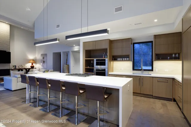a kitchen with stainless steel appliances granite countertop a table chairs sink and cabinets