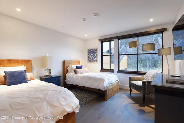 a bedroom with two beds and a large window
