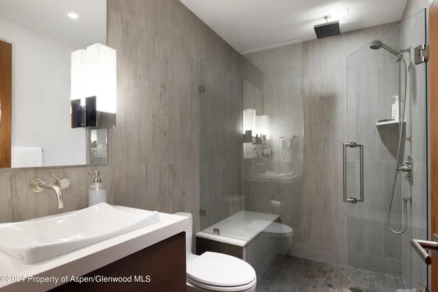 a bathroom with a sink toilet and shower