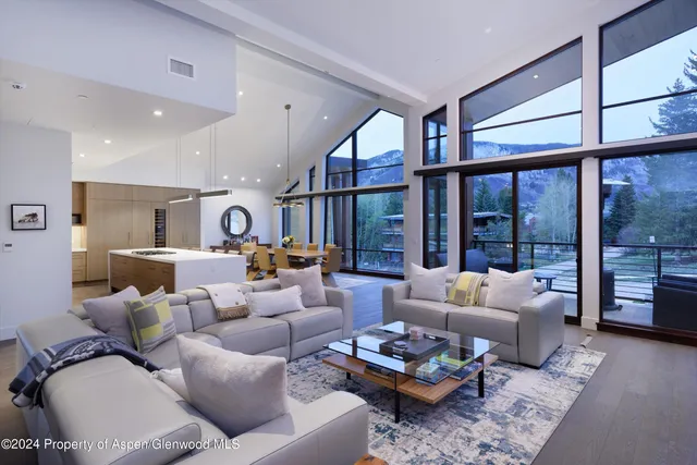 a living room with furniture wooden floor and a large window