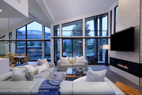 a living room with furniture tv and a floor to ceiling window
