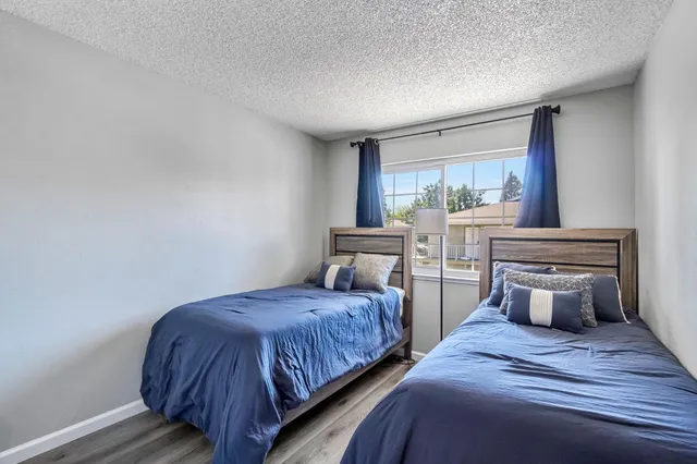 a bedroom with two beds and a large window