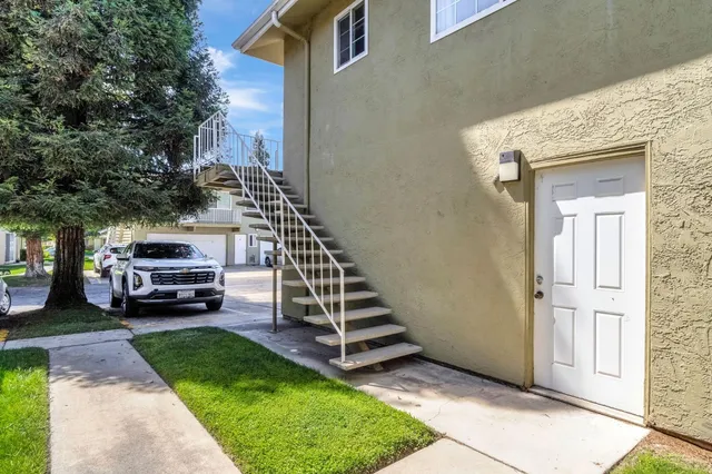 a view of a couches in the patio with a small yard