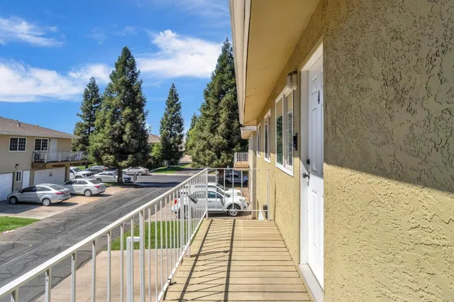 a view of a balcony with wooden floor and fence