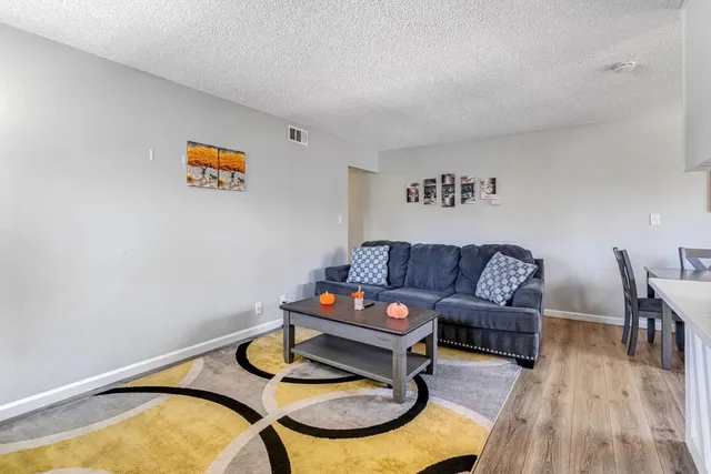 a living room with furniture and wooden floor