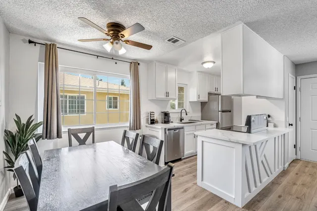a kitchen that has a lot of cabinets a sink and appliances