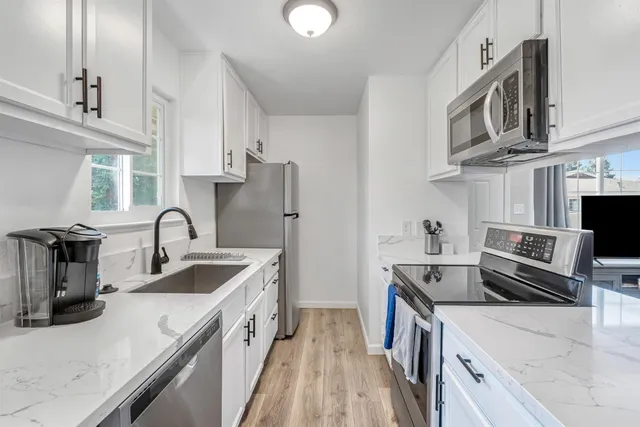 a kitchen with stainless steel appliances granite countertop a sink stove and refrigerator