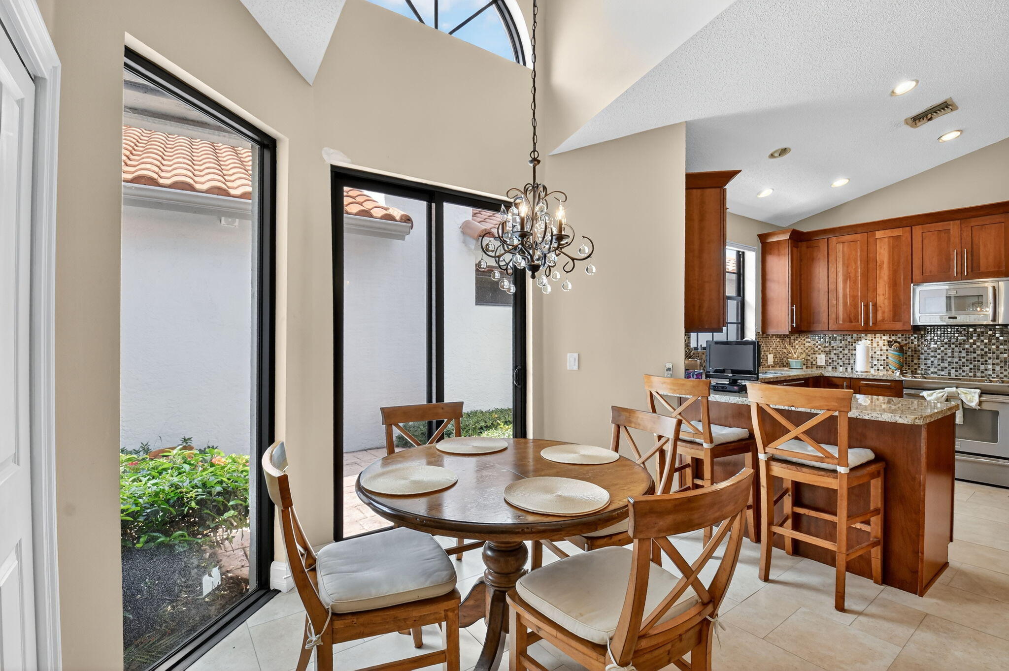 5850 Northwest 21st Avenue Boca Raton, FL 33496 - Photo 16 of 54 a view of a dining room with furniture and a chandelier