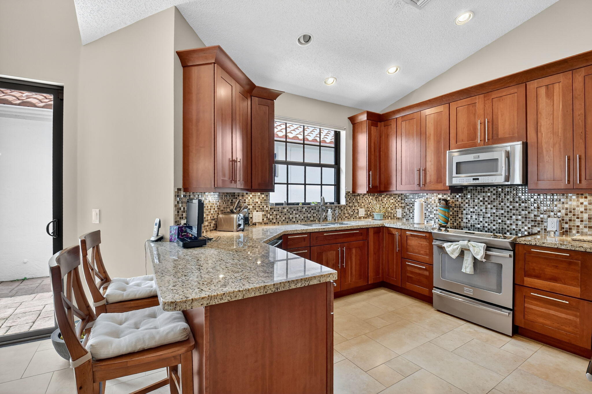 5850 Northwest 21st Avenue Boca Raton, FL 33496 - Photo 18 of 54 a kitchen with stainless steel appliances granite countertop a sink dishwasher stove and refrigerator