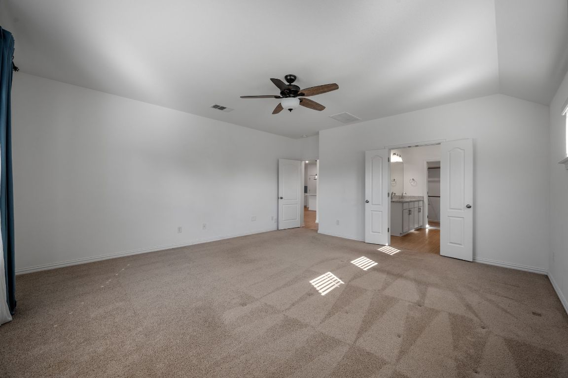 1109 Morning View Road Georgetown, TX 78628 - Photo 15 of 40 an empty room with chandelier fan and windows