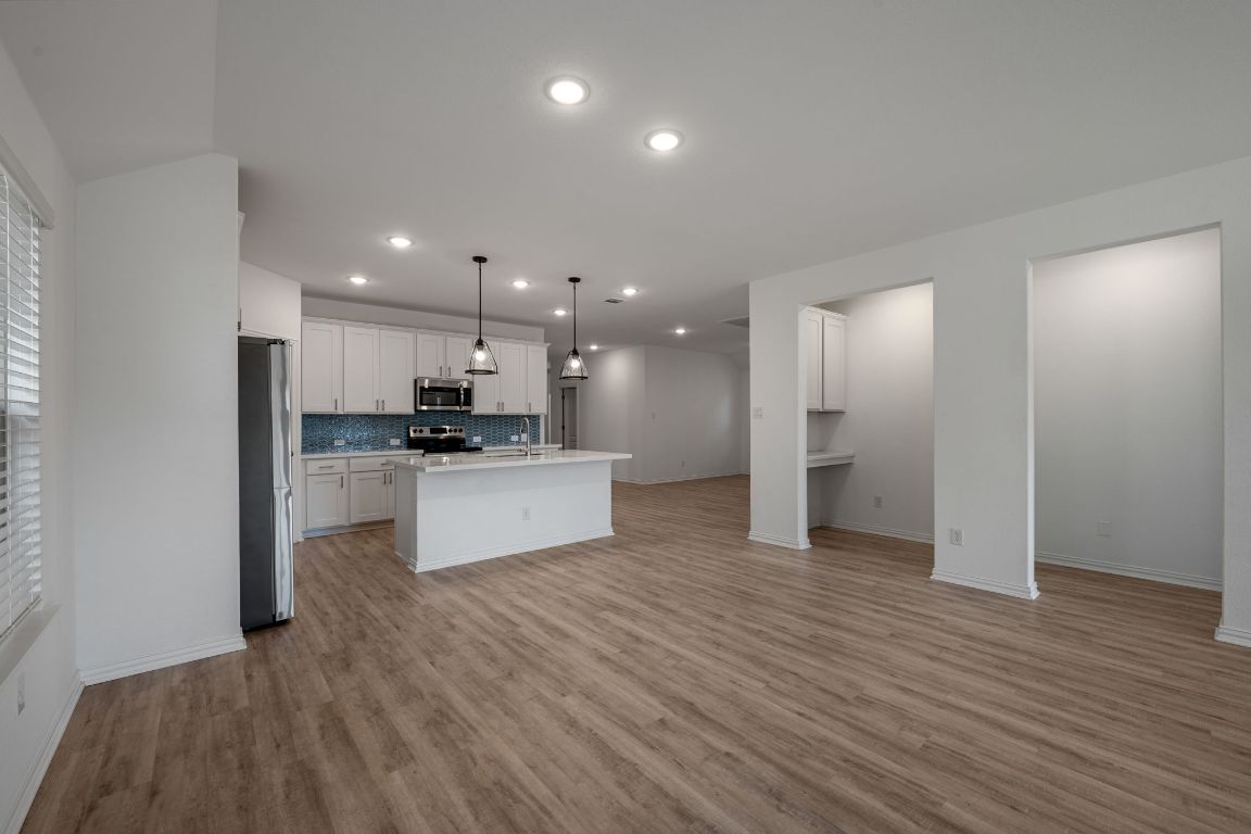 1109 Morning View Road Georgetown, TX 78628 - Photo 39 of 40 a view of kitchen with kitchen island wooden floor granite counter tops and white cabinets