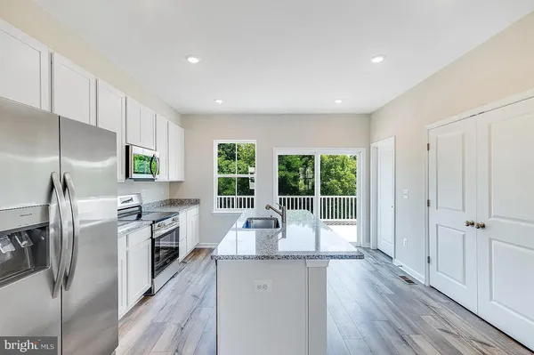 a view of a kitchen with wooden floor and electronic appliances