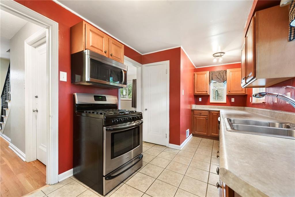 1161 Prospect Road Pittsburgh, PA 15227 - Photo 13 of 39 a kitchen with stainless steel appliances granite countertop a stove a sink and a microwave