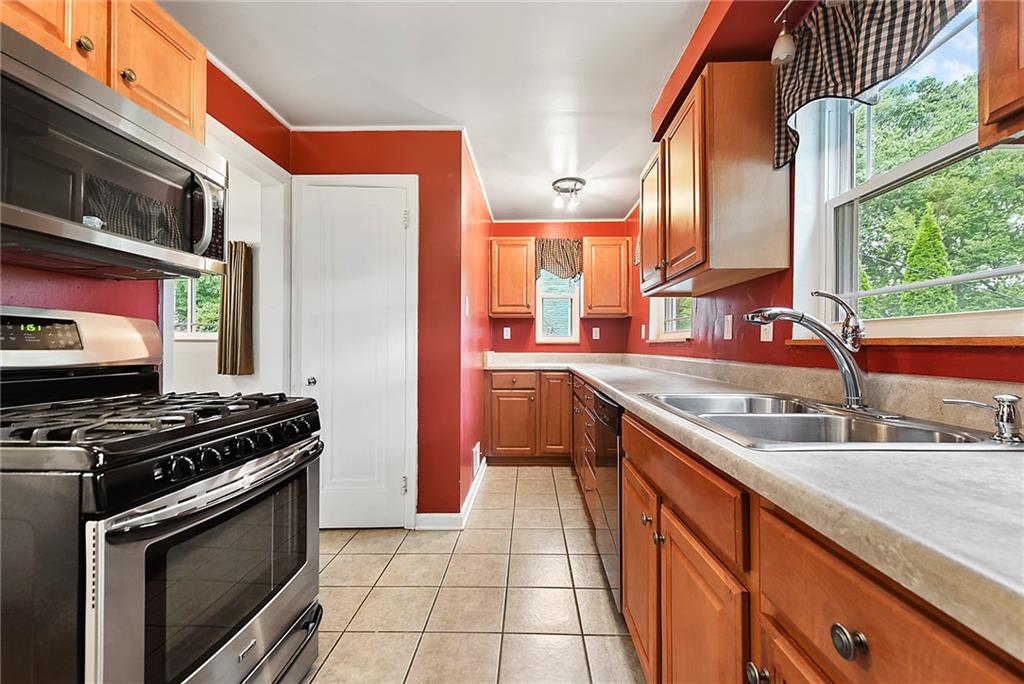 1161 Prospect Road Pittsburgh, PA 15227 - Photo 14 of 39 a kitchen with stainless steel appliances granite countertop a stove a sink and a microwave