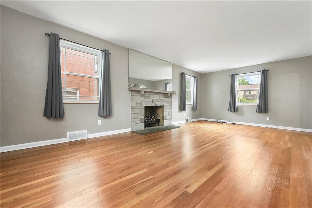 1161 Prospect Road Pittsburgh, PA 15227 - Photo 10 of 39 an empty room with wooden floor and fireplace