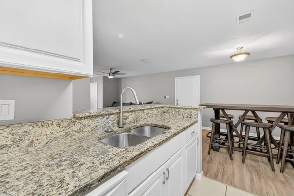 a kitchen with a sink a table and chairs
