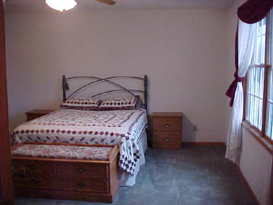 8188 Mcmichael Road Caledonia, IL 61011 - Photo 3 of 6 a bed sitting in a room next to a lamp