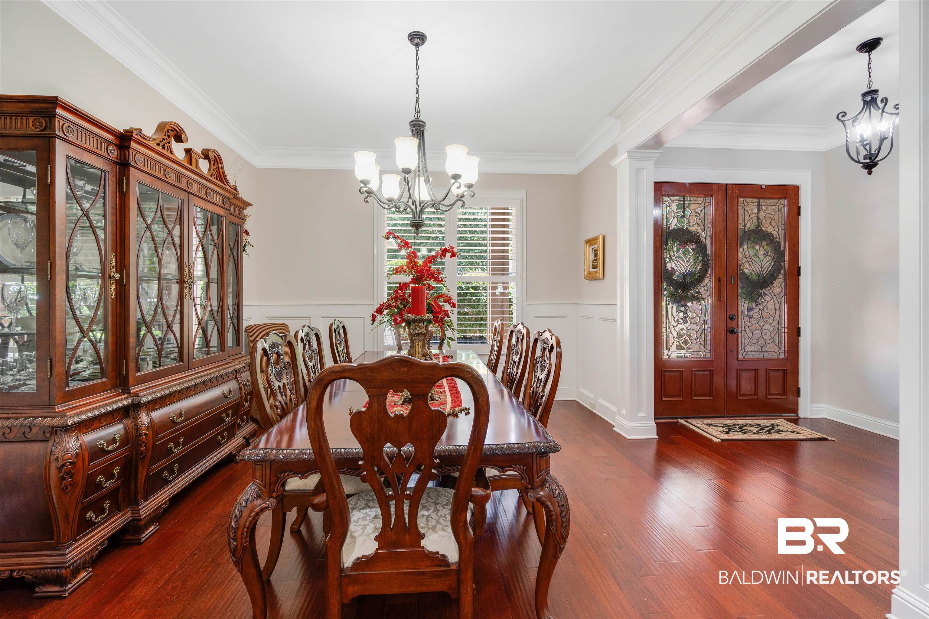 Dining space featuring ornamental molding, dark hardwood / wood-style floors, an inviting chandelier, and ornate columns