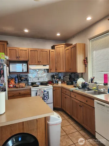 a kitchen with kitchen island granite countertop a sink stainless steel appliances and cabinets