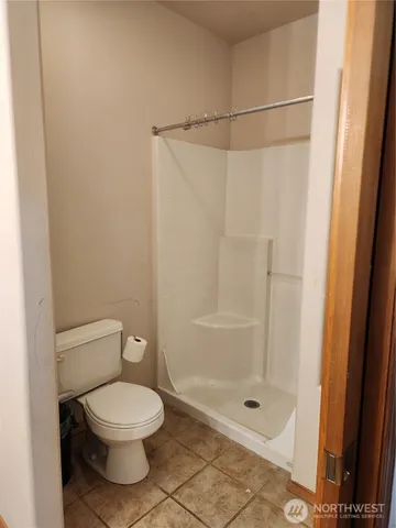a bathroom with a toilet and a shower