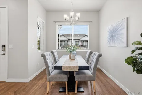 a view of a dining room with furniture a chandelier and wooden floor