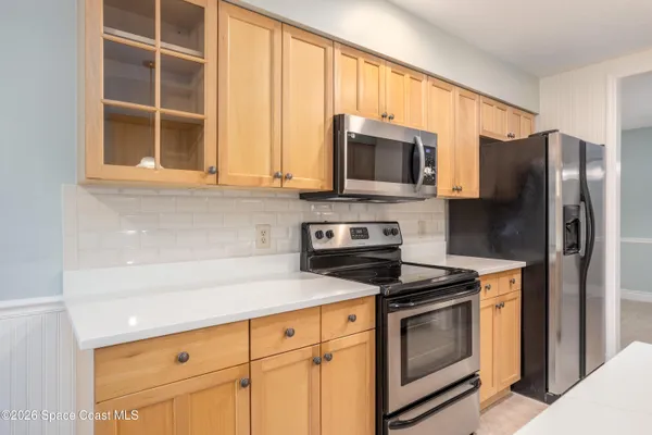 a kitchen with stainless steel appliances granite countertop a sink a stove and a refrigerator