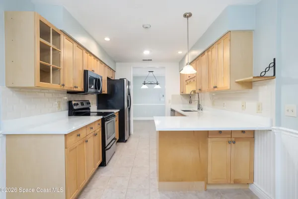 a kitchen with kitchen island a sink a counter top space and stainless steel appliances