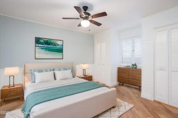 an empty room with wooden floor and ceiling fan