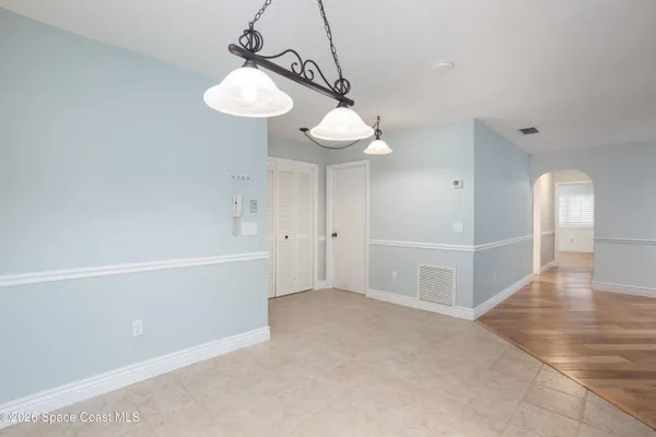 a view of an empty room with a chandelier fan