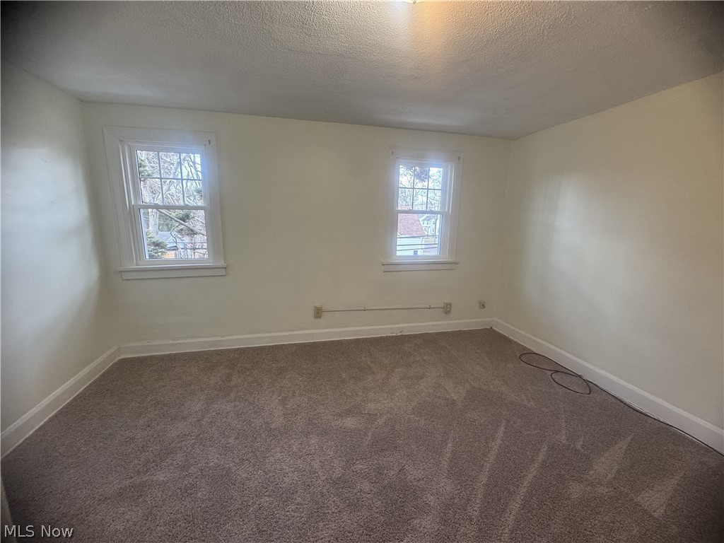 4058 Ardmore Road Cleveland, OH 44121 - Photo 14 of 14 Empty room featuring dark carpet and a textured ceiling