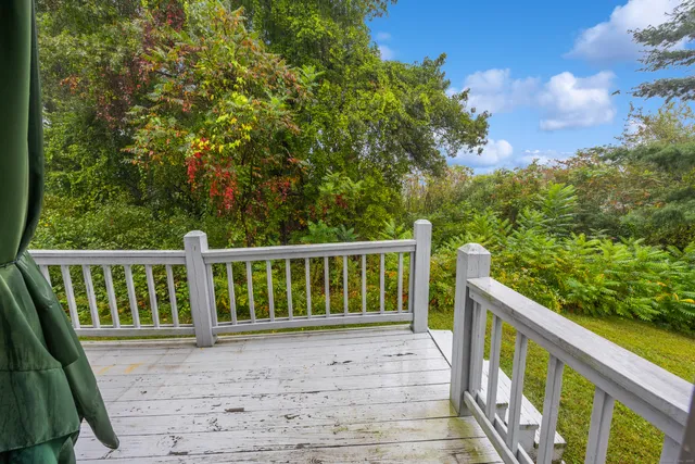 a view of balcony with wooden floor and fence
