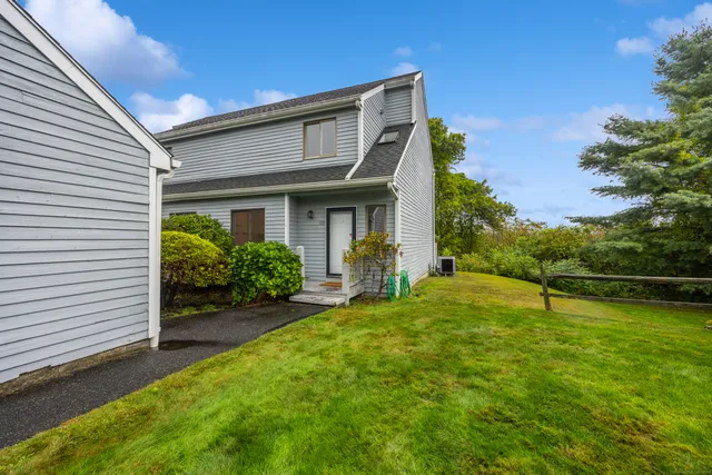 a view of a house with backyard and sitting area