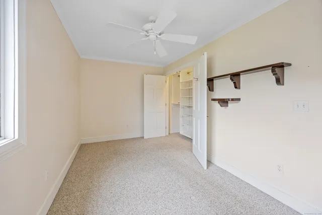 a view of a big room with a ceiling fan and a window